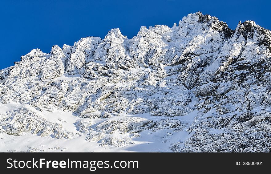 Winter rocky mountain peak in High Tatras, Slovakia, with blue sky background