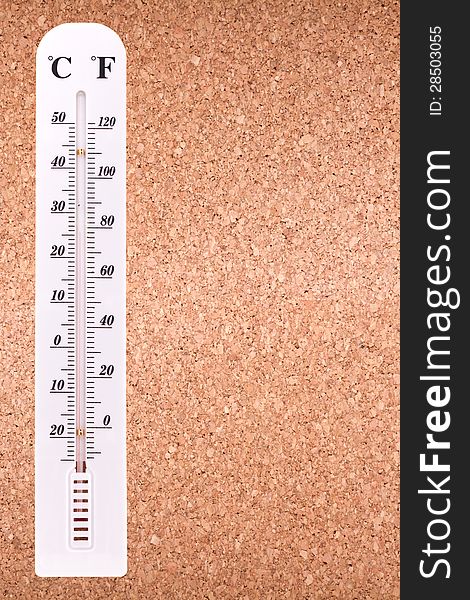 White thermometer on a corkboard with copy space. White thermometer on a corkboard with copy space.