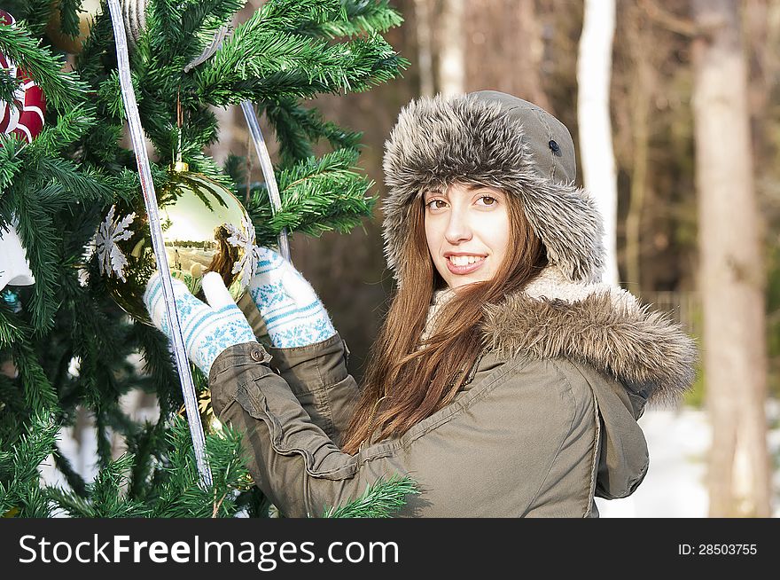 The girl decorates a Christmas tree