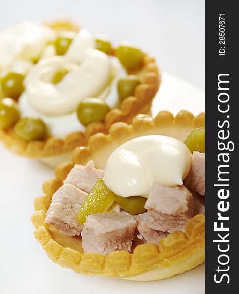 Tartlet with salad on a white plate .Shallow depth-of-field