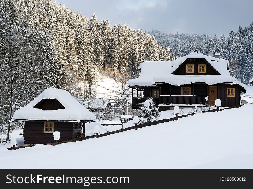 Wooden chalet or cottage in mountain holiday resort covered with fresh snow in winter. Wooden chalet or cottage in mountain holiday resort covered with fresh snow in winter.