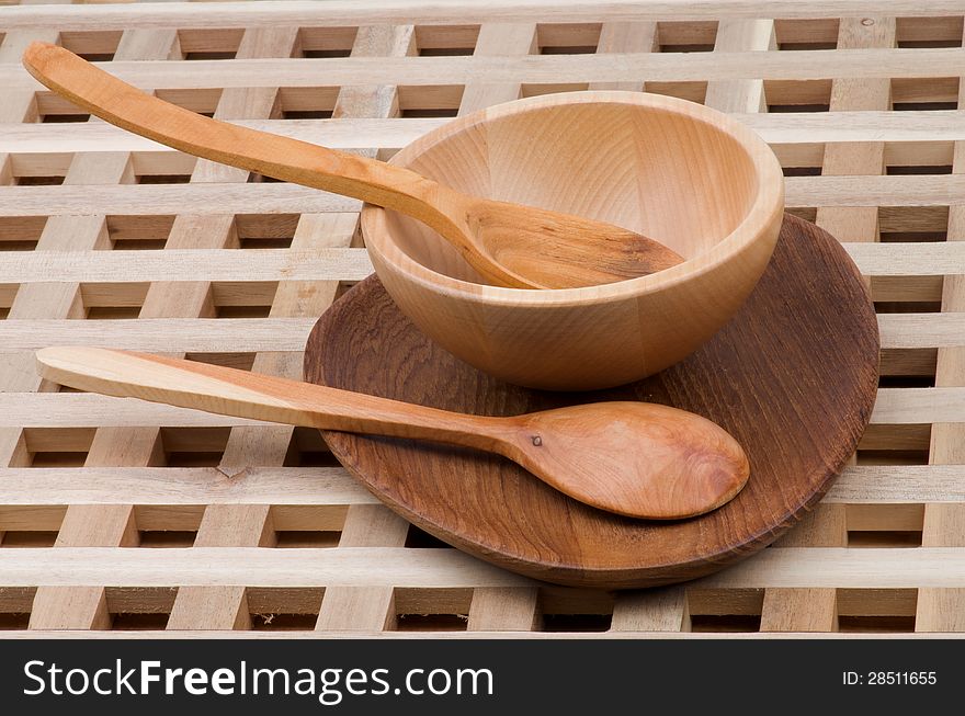 Wood Kitchen Utensil with Spoons, Plate and Bowl closeup on Wooden background