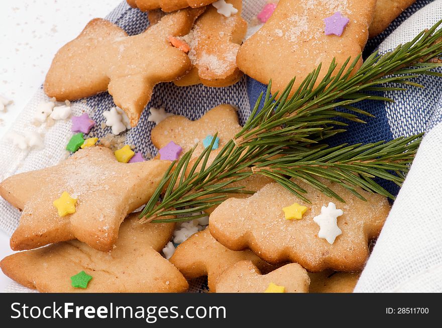 Gingerbread Cookies decorated with Colorful Sprinkles, Sugar Powder and Fir closeup on Napkin