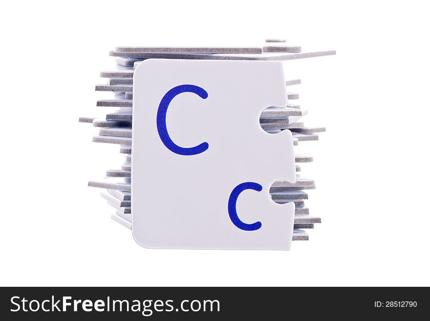 Letter C of puzzle alphabet on a bunch of other puzzle alphabet pieces isolated on white. Letter C of puzzle alphabet on a bunch of other puzzle alphabet pieces isolated on white.