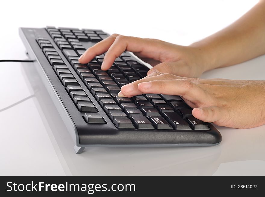 Woman hand typing on black computer keyboard over white background. Woman hand typing on black computer keyboard over white background