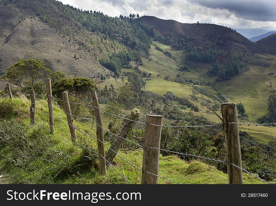 Barbed wire fence in the serria of ecuador with andes mountains in background. Barbed wire fence in the serria of ecuador with andes mountains in background