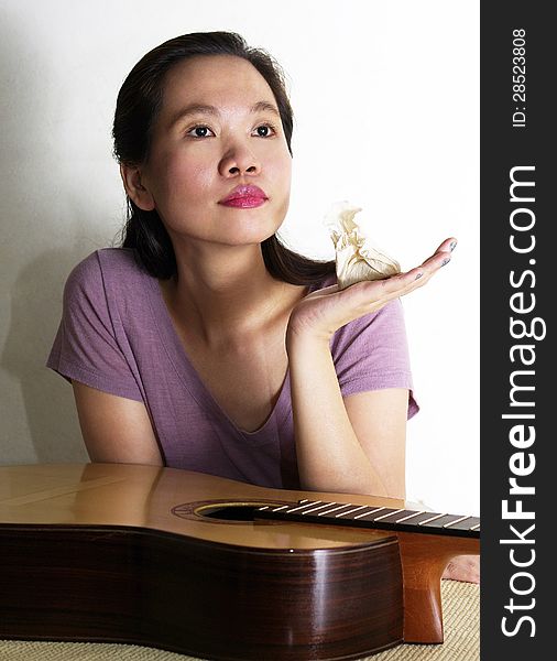 A portrait of attracttive asian woman varnishing guitar. A portrait of attracttive asian woman varnishing guitar