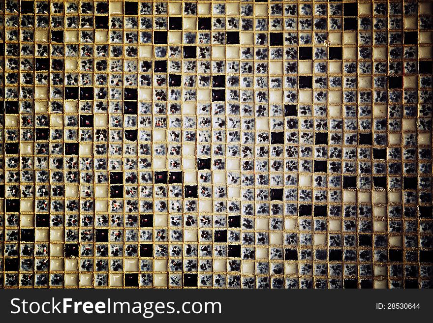 Architectural background of an unusual speckled mosaic wall with a central highlight