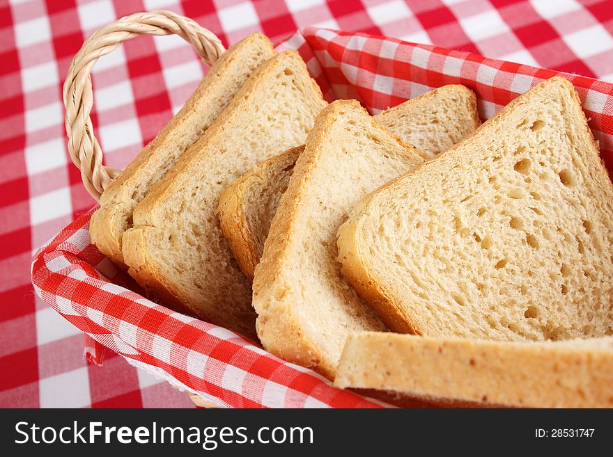 Sliced bread in a basked , red and white check background
