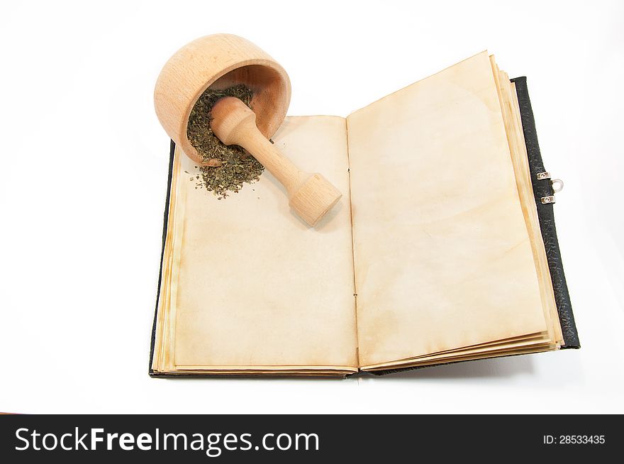 Mortar with herbs on the book. Mortar with herbs on the book