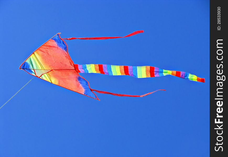 Beautiful colorful kite soaring in the blue sky. Beautiful colorful kite soaring in the blue sky