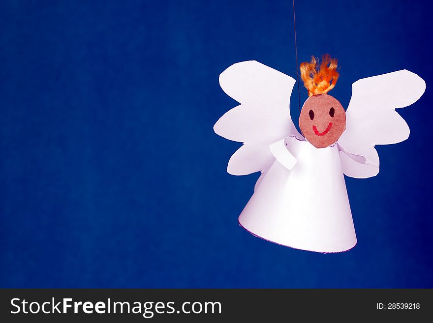 Cheerful boy paper angel on a blue background. Cheerful boy paper angel on a blue background