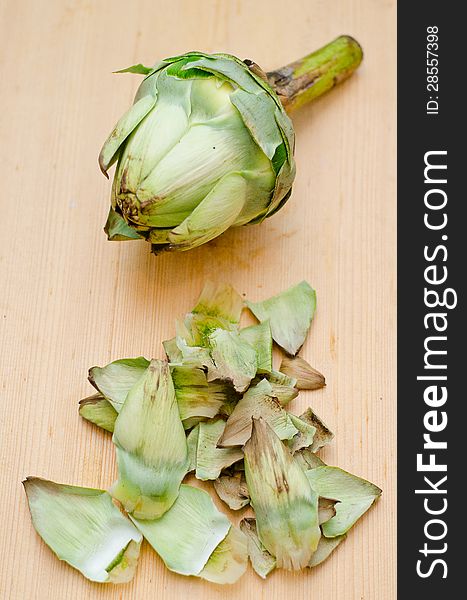Removing dry leaves from a globe artichoke. Removing dry leaves from a globe artichoke
