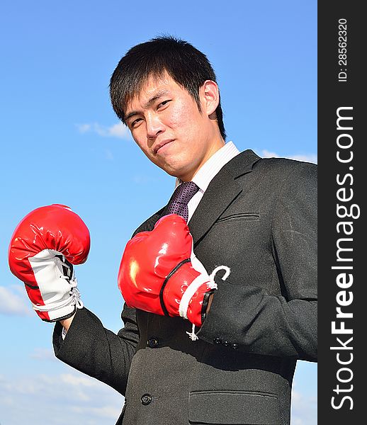 Close up businessman and hand boxing glove ready to fight over blue sky. Close up businessman and hand boxing glove ready to fight over blue sky.