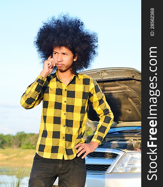 Close up of Long-haired young man on the cellphone for help