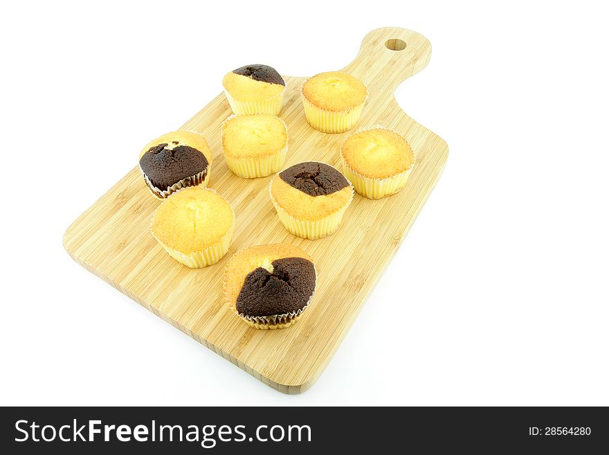 Plain and chocolate muffins on a wooden board. On a white background.