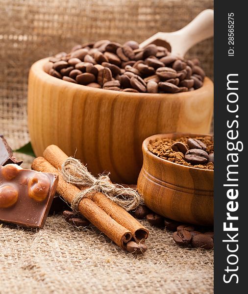 Coffee beans in a wooden bowl on burlap background