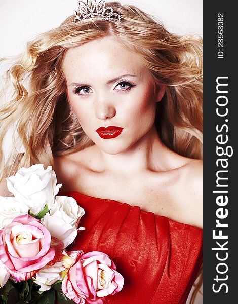 Beautiful Fashion Girl with red makeup and Roses. Hairstyle