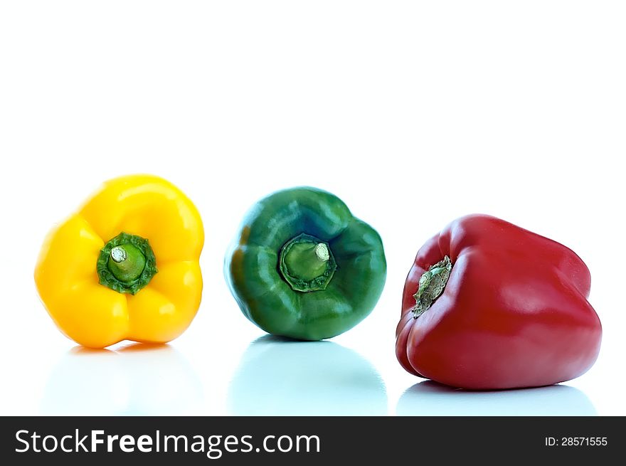 Three differently colored peppers on a white background