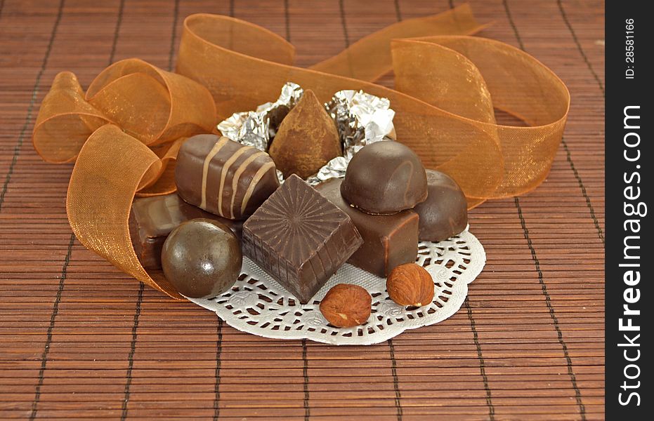 Chocolate candies on the white napkin with brown ribbon