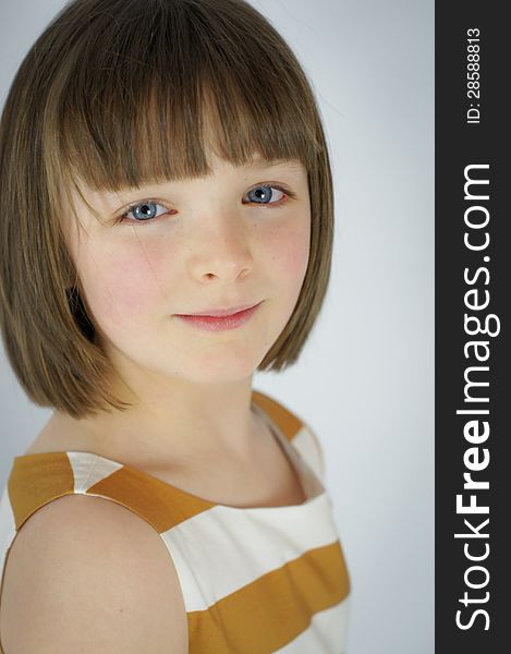 A simple portrait of a young girl with a slight smile. A simple portrait of a young girl with a slight smile.