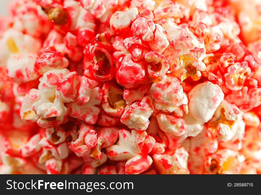 Sweet popcorn with pink sugar syrup background. Selective focus.