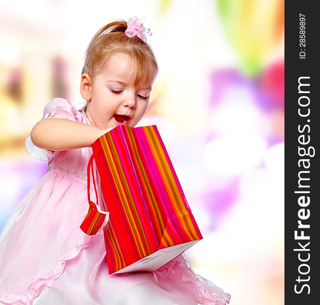 Portrait of the girl in the mall holding a gift