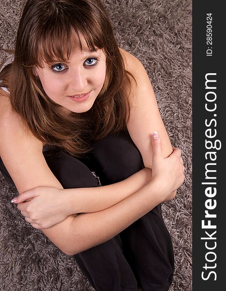 Young girl is sitting on the carpet. Young girl is sitting on the carpet.