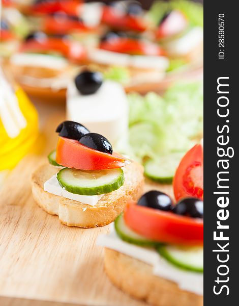 Preparing canapés with vegetables and cheese