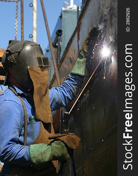 Metallurgist is welding with protection Ã©quipment