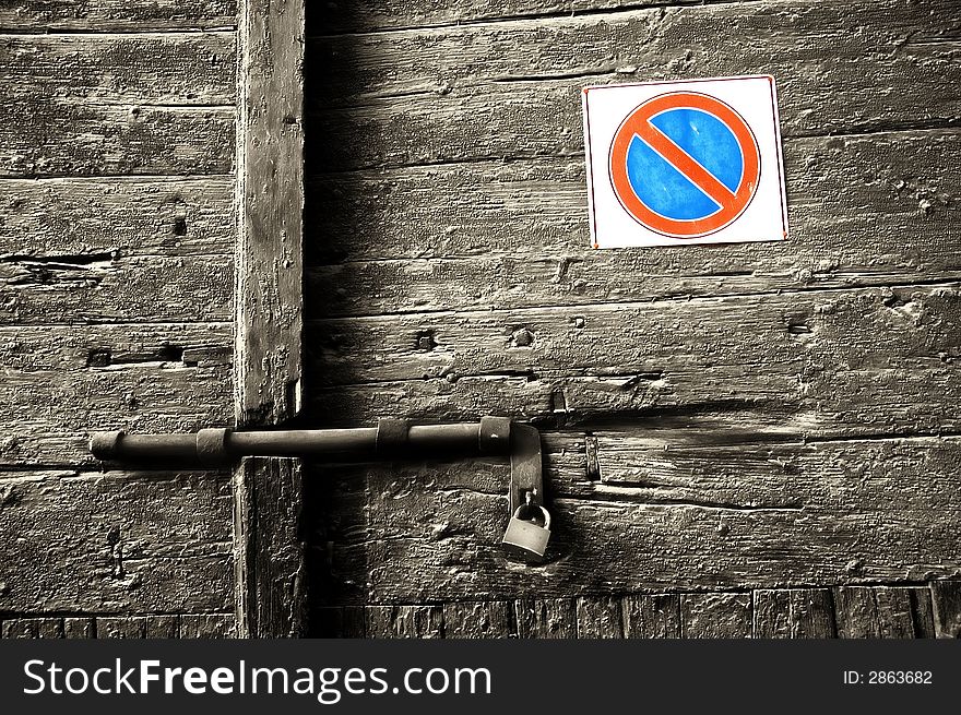 Forbidden sign on decayed wooden door with lock