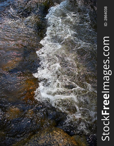 Small rapids and spray in a little river. Small rapids and spray in a little river