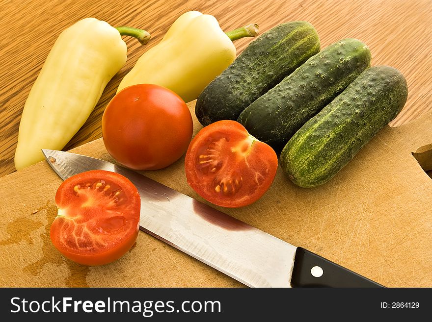 Sliced tomatoes, cucumbers and peppers on board. Sliced tomatoes, cucumbers and peppers on board