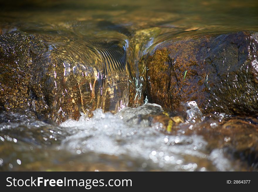 Little rill with brown stones and rocks