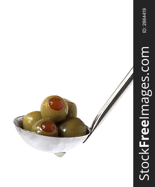 A spoon of stuffed green olives on a white background. A spoon of stuffed green olives on a white background.