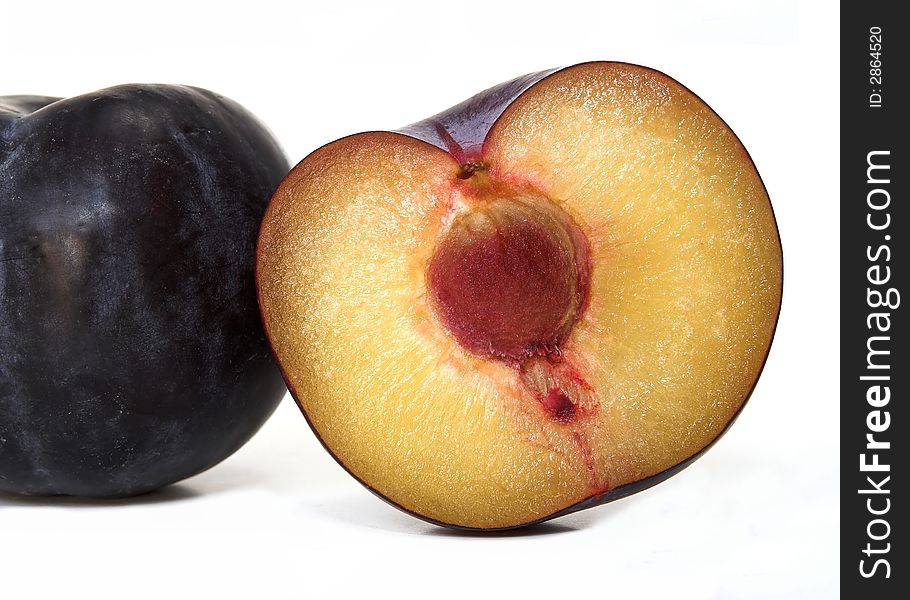 Two ripe juicy plums, one cut in half. Two ripe juicy plums, one cut in half.