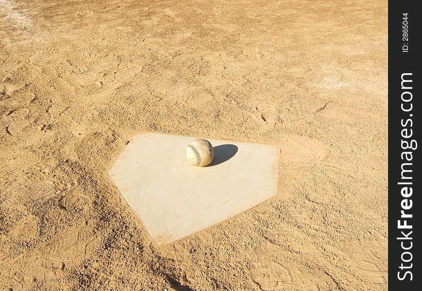 Home plate on a baseball field with a baseball set on it