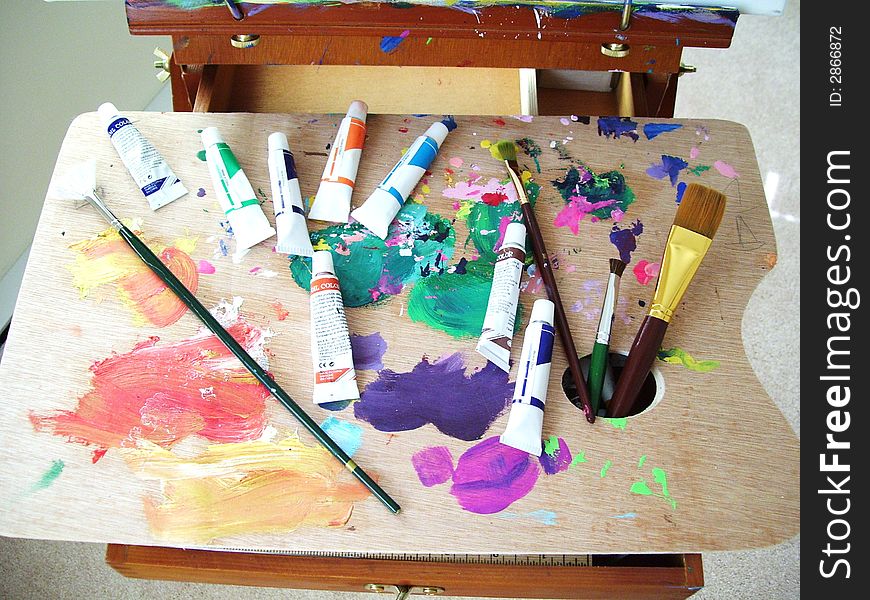 Art palette with colors and brushes.