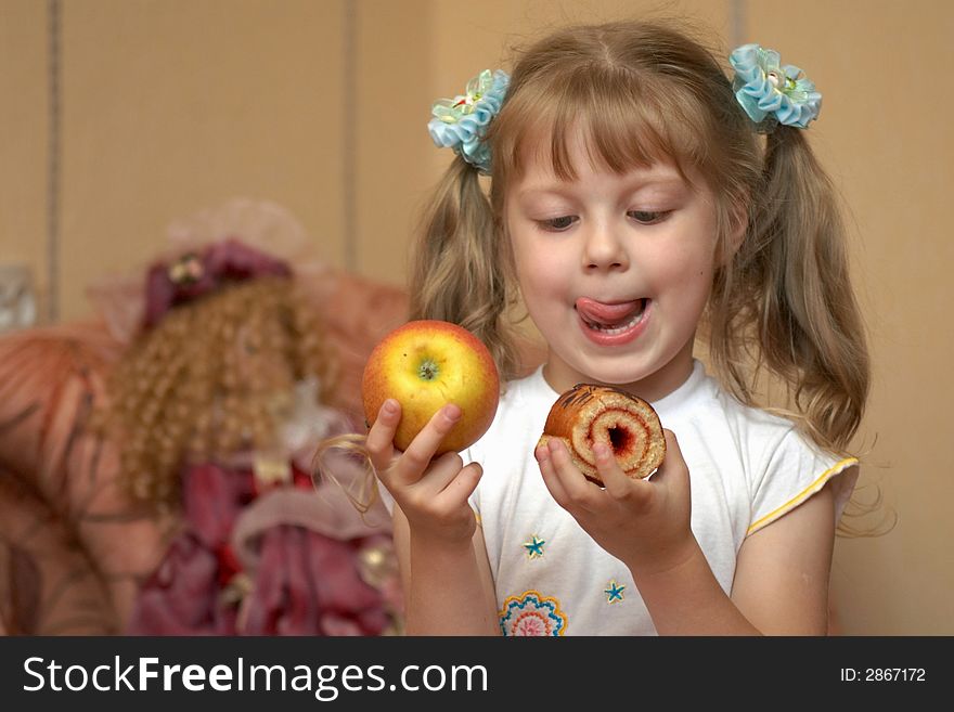 A girl holding an apple and a cake. A girl holding an apple and a cake