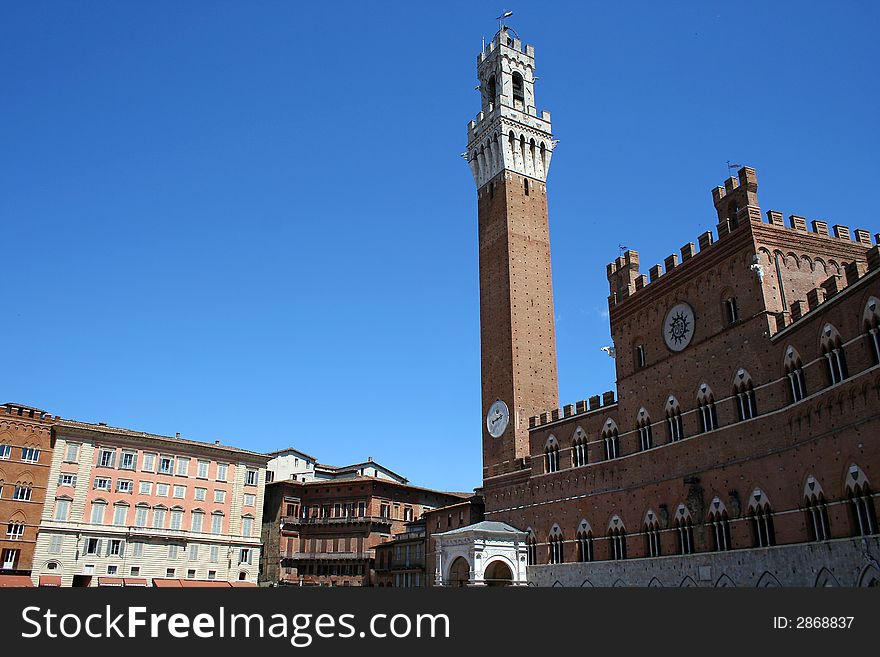 Photograph of the beautiful Palazzo Publico and Torre del Mangia, the two main monuments on the famous Piazza del Campo in the town of Siena, Italy. Photograph of the beautiful Palazzo Publico and Torre del Mangia, the two main monuments on the famous Piazza del Campo in the town of Siena, Italy