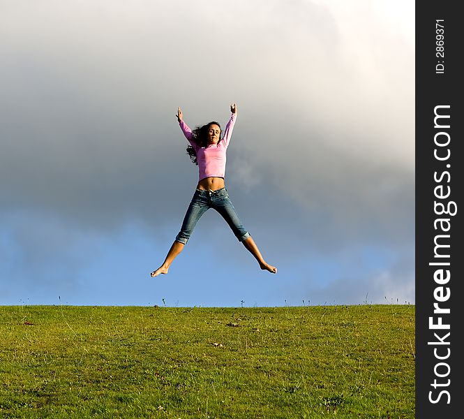 Happy young beautiful girl jumping in the green field. Happy young beautiful girl jumping in the green field.