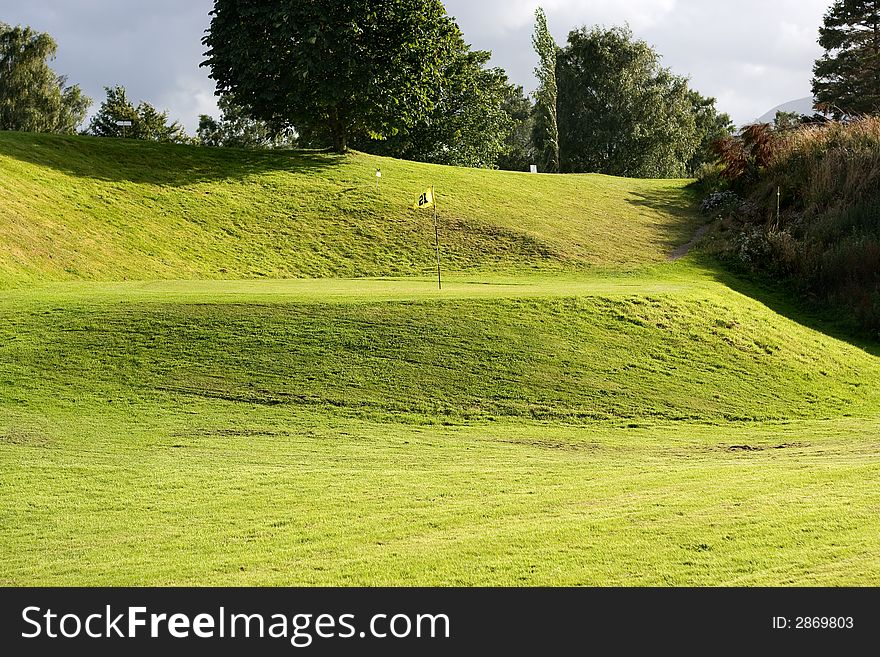 Golf field with yellow flag. Golf field with yellow flag.