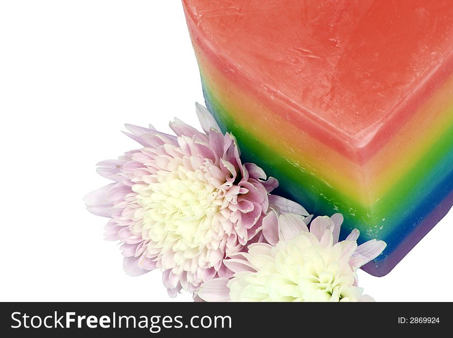 Multi coloured candle with flowers against a white background. Multi coloured candle with flowers against a white background