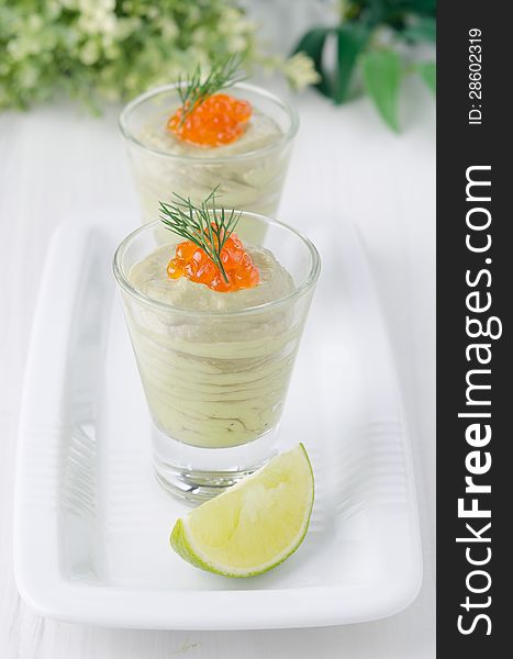 Avocado cream and red caviar in glasses. Avocado cream and red caviar in glasses