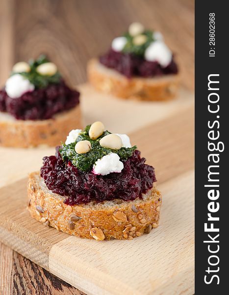 Beet salad with pesto and goat cheese on toasted grain breads on