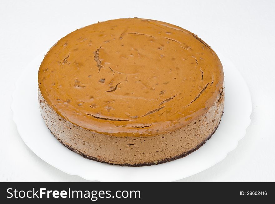 Chocolate cheesecake on a plate on a white background, closeup. Chocolate cheesecake on a plate on a white background, closeup