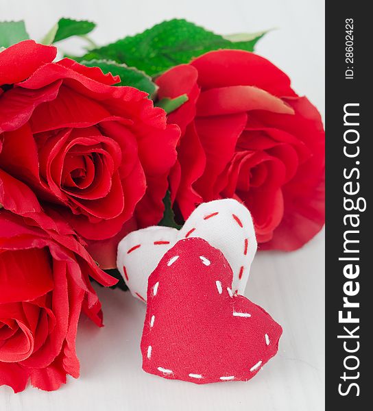 Canvas handmade hearts and red roses for Valentines day on a white table