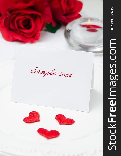 Greeting Valentine's Day card on a plate, roses and candle. Greeting Valentine's Day card on a plate, roses and candle