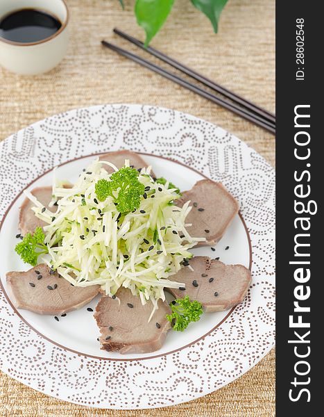 Oriental salad with beef tongue, celery and cucumber on a plate, top view. Oriental salad with beef tongue, celery and cucumber on a plate, top view