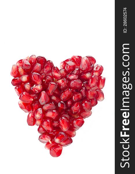 Pomegranate seeds in heart shape isolated on a white background